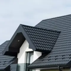 Nowy, ciemny dach z blachodachówki, idealny po wymianie starego pokrycia. Wygląda solidnie i nowocześnie.