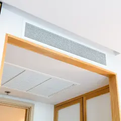 Nowoczesna klimatyzacja kanałowa dyskretnie wkomponowana w sufit, zapewniająca komfort w stylowym wnętrzu.