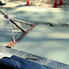 Chudziak wyrównuje świeży beton.