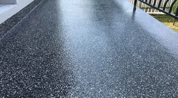 Nowoczesna żywica na balkon cena za metr. Ciemnoszara posadzka z brokatem, idealna na taras.