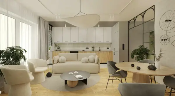 Nowoczesny salon z aneksem kuchennym, jasna sofa, okrągły stół, designerskie fotele i rośliny.