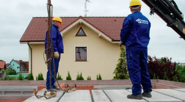 Pracownicy montują prefabrykowane płyty, prezentując różne rodzaje stropów. Budowa domu z wykorzystaniem nowoczesnych technologii.