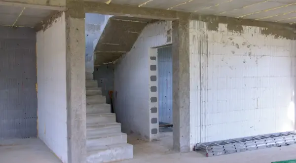 Wnętrze budowy, schody betonowe, otwór pod drzwi 80, ściany z bloczków, drabina.