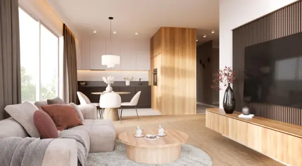 Przytulny salon z elementami stylu japandi: jasna sofa, drewniany stolik kawowy, kuchnia z wyspą i jadalnia.