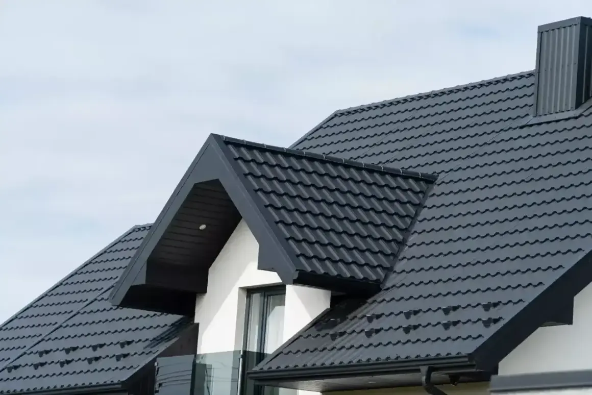 Nowy, ciemny dach z blachodachówki, idealny po wymianie starego pokrycia. Wygląda solidnie i nowocześnie.