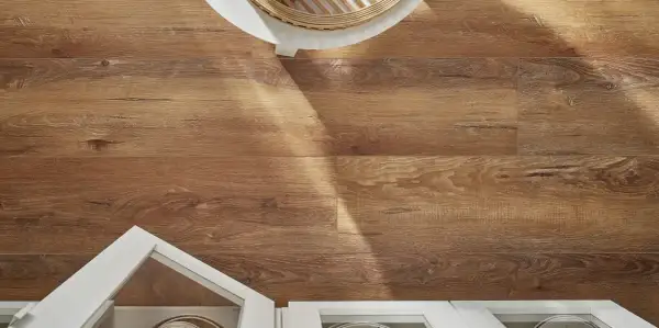 Drewniane panele w kuchni tworzą ciepłą atmosferę. Widoczne białe szafki i fragment stołu dodają elegancji.
