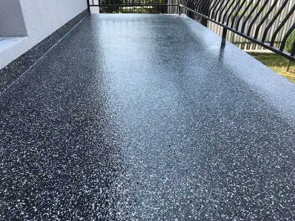 Nowoczesna żywica na balkon cena za metr. Ciemnoszara posadzka z brokatem, idealna na taras.