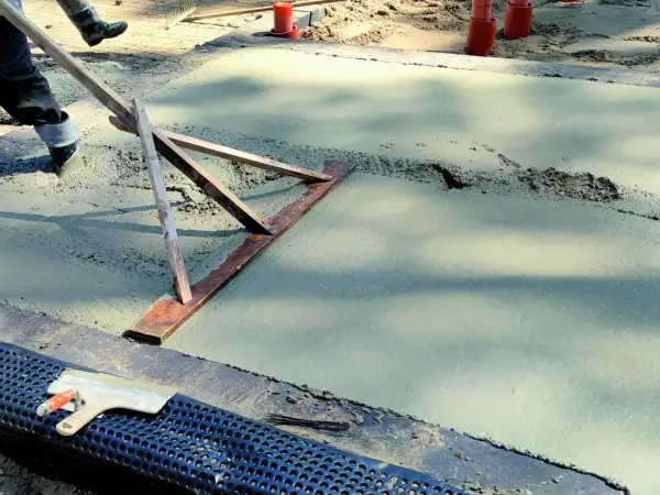 Chudziak wyrównuje świeży beton.
